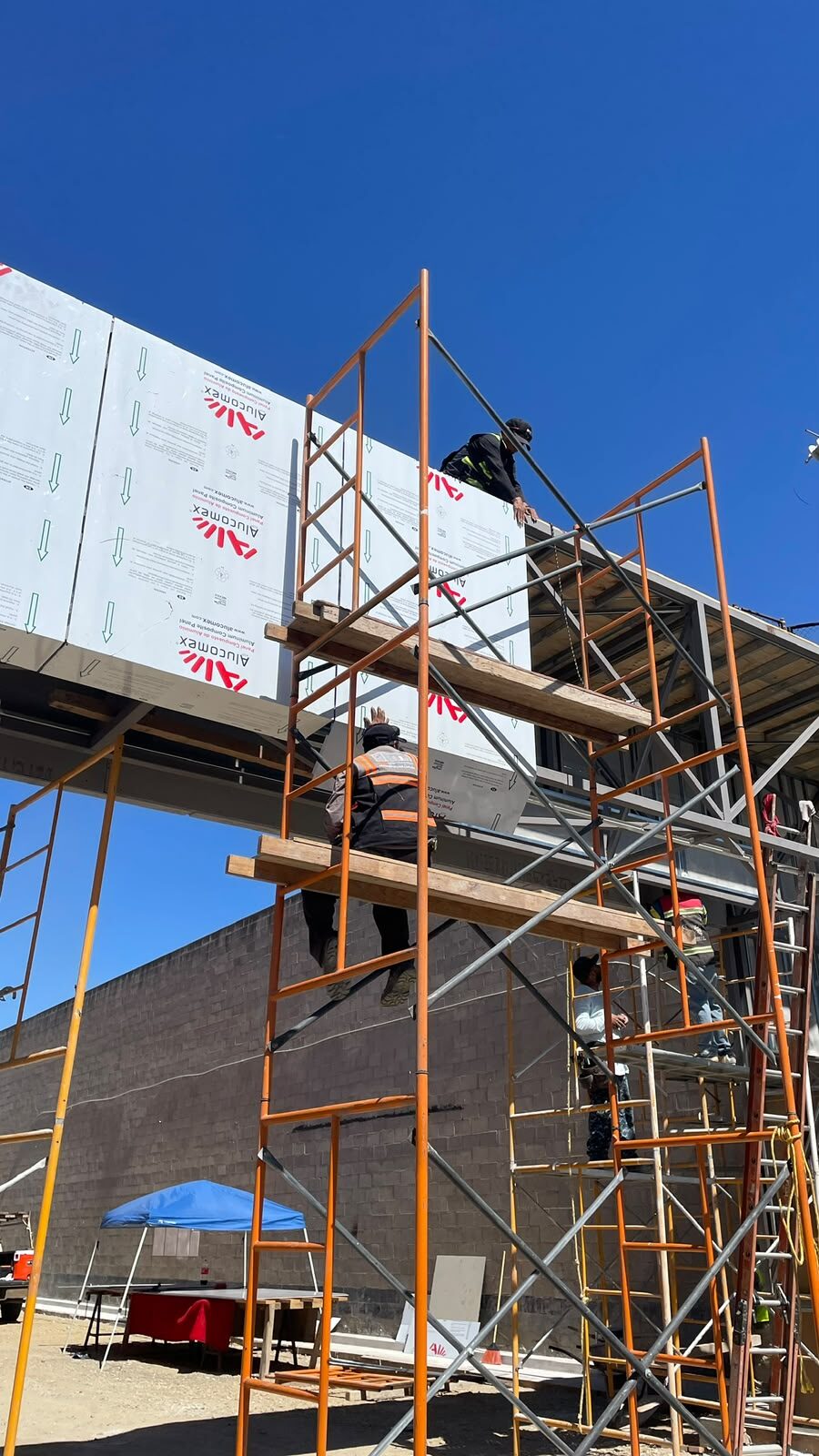Obra: cuadrilla trabajando en la fachada con andamios — Master Storage Otay Hub