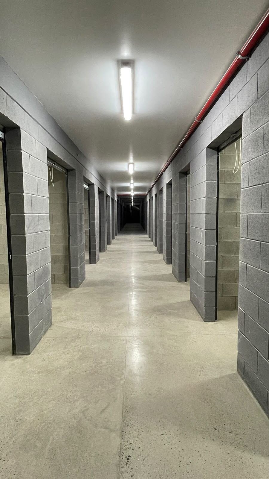 Obra: pasillo de mini bodegas iluminado — Master Storage Otay Hub